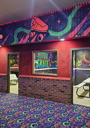 Colorful roller skate-themed decor with neon lights, featuring the words "Super Skate" on a vibrant wall, in a fun, lively atmosphere.