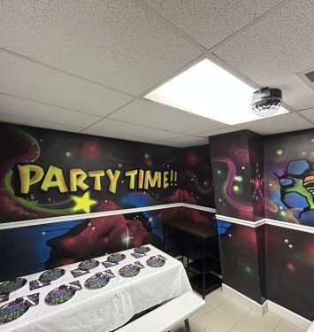 A vibrant party room featuring a colorful mural on the wall, creating a lively and festive atmosphere.