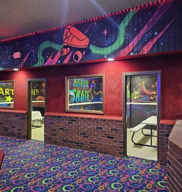 A vibrant bowling alley featuring neon signs and a colorful carpet, creating a lively and energetic atmosphere.