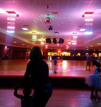 A spacious room filled with people skating on a smooth floor, enjoying the activity and socializing with one another.