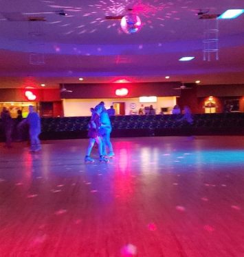 A spacious room filled with people joyfully dancing on the floor, creating a lively and festive atmosphere.